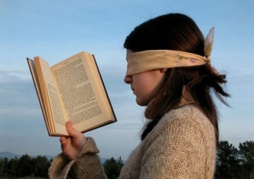 A Blindfolded Young Woman Reading A Book.