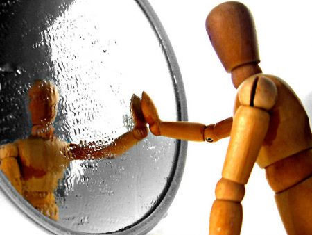 Wood Toy Puppet Figure Looking In A Mirror.