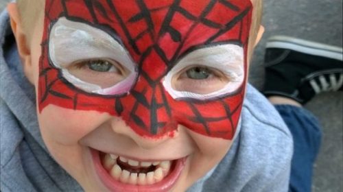 Child Wearing Superhero Spiderman Type Painted Face Mask.