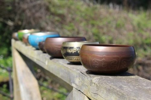 Featured Topic Image Row Of Singing Bowls Lined Up On A Fence/Gate.