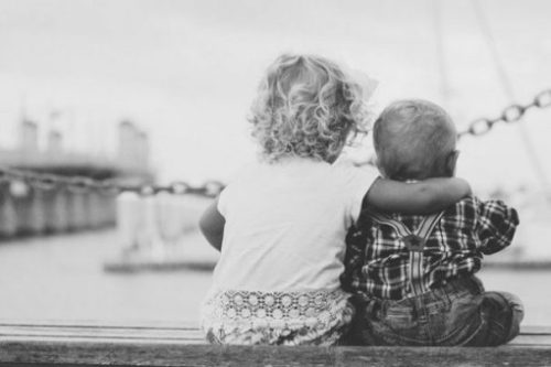 Image Of Two Young Children Overlooking A City And Harbour Waters View.