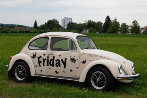 Featured Image Of A White Vw Car With Friday Painted On It's Side Sitting In A Grassy Field.