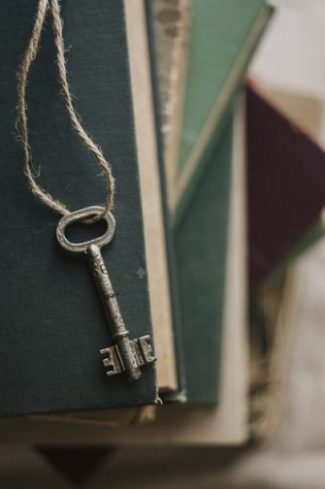 Image Of A Small Key Dangling Over Several Books.