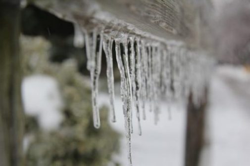Image Of A Row Of Icicles On A Roof Support.