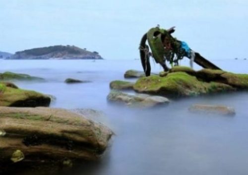 Image Of A Misty Shoreline Focusing On An Old Half Buried Anchor.