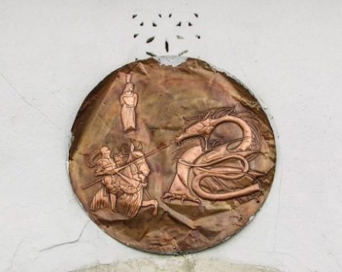 Featured Image Of An Ornate Copper Medallion With Knight And Dragon Legend Drawn/Etched On.